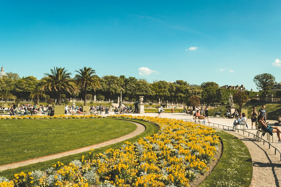 Curved pathway in yellow flower and green trees garden in Paris France